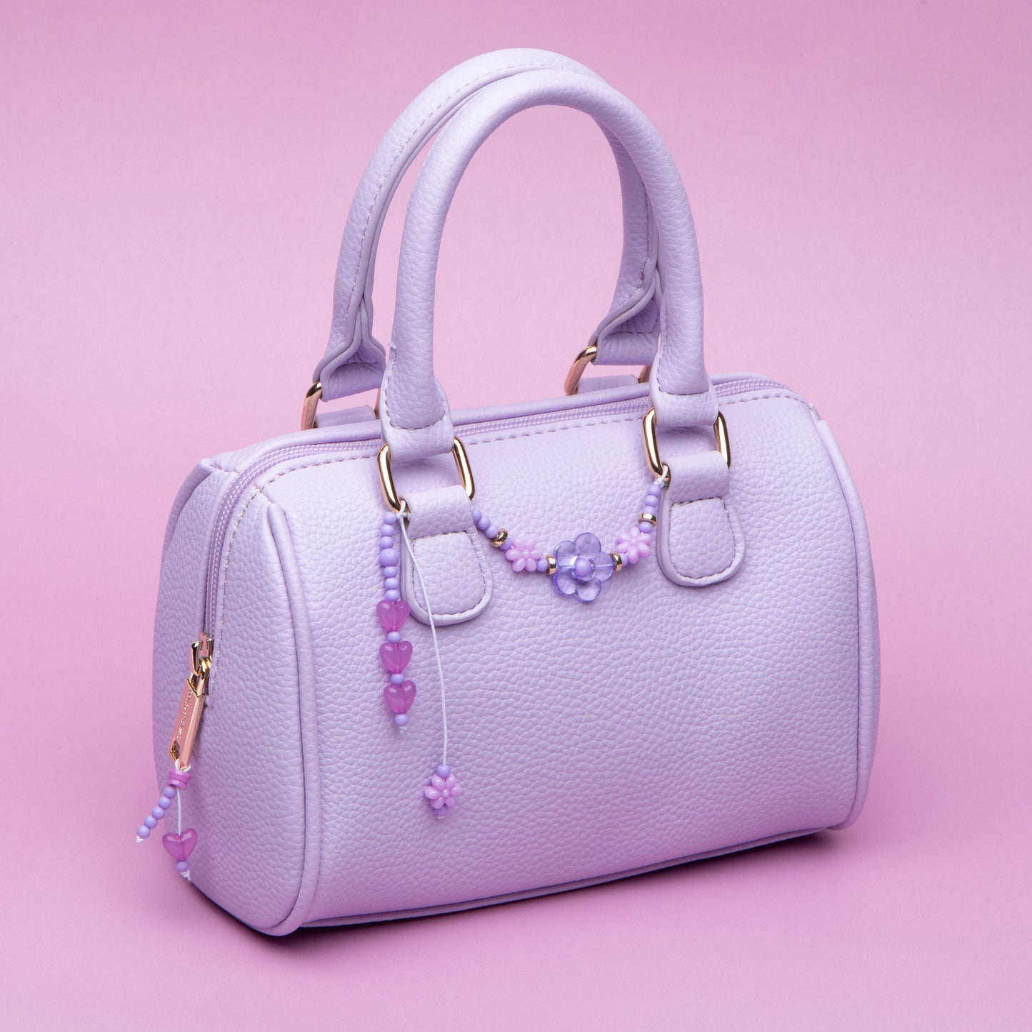 A purse with a beaded zipper pull and a beaded swag on the front.