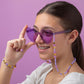 A tween wearing a beaded bracelet and sunglasses with a beaded chain.