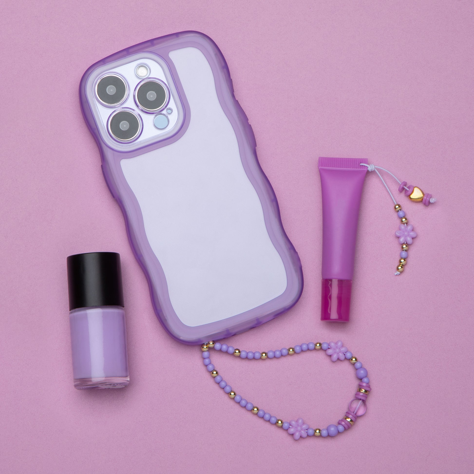A phone case with a beaded handle and a lip gloss with a beaded tassel.